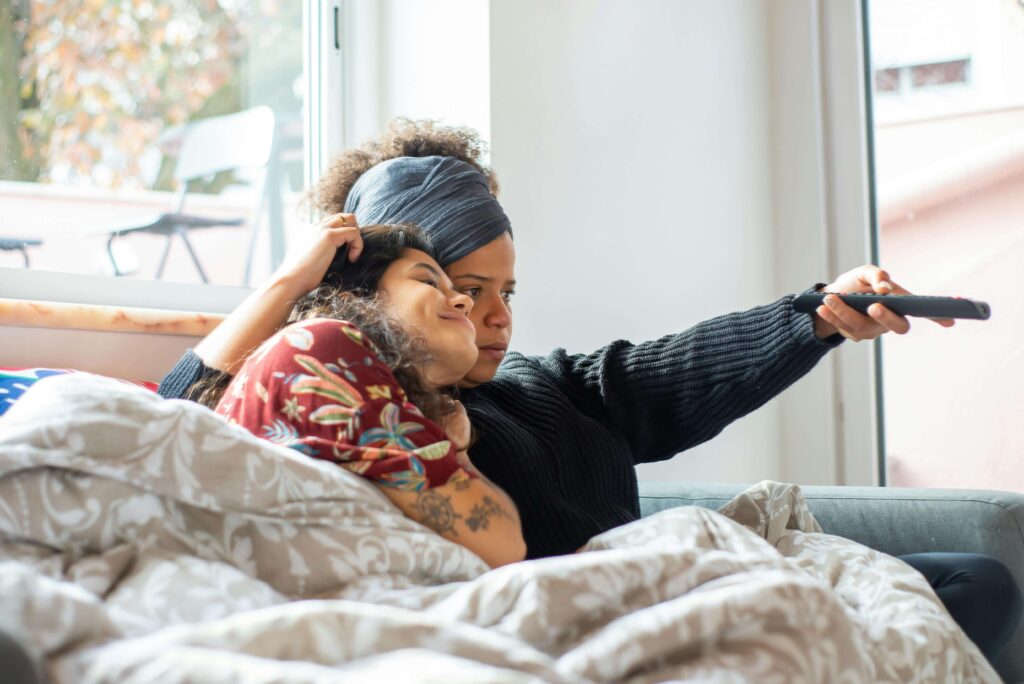 Chinese woman sitting on the floor while watching TV at home.