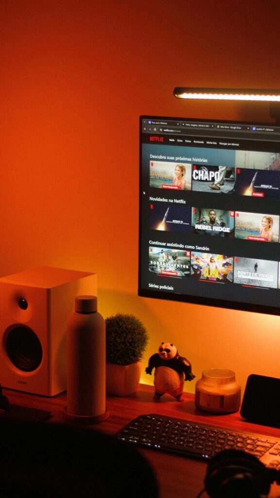 A television displaying a film selection menu, with a large soundbar beneath it in a cosy room.
